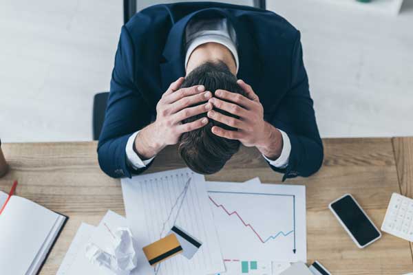 top-view-of-depressed-businessman-holding-hands-on-head